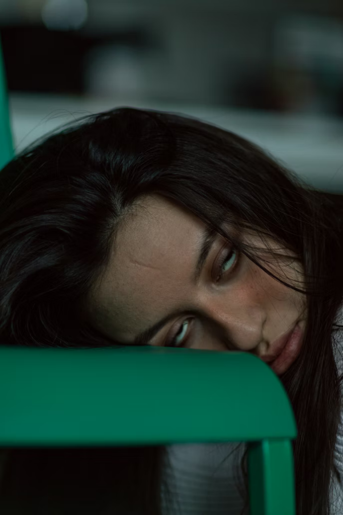 Bored woman rests her head on a green table